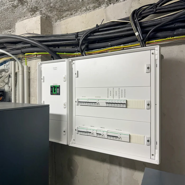 Salle de bain moderne avec toilettes suspendues blanches, baignoire avec pare-douche, robinetterie murale chrome