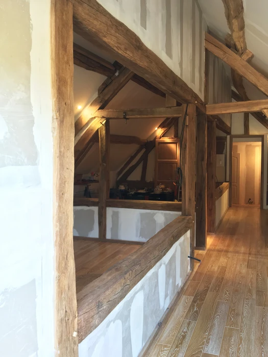 Salle de bain moderne rénovée avec baignoire d'angle, meuble vasque suspendu bleu, miroir encadré bois et placards muraux