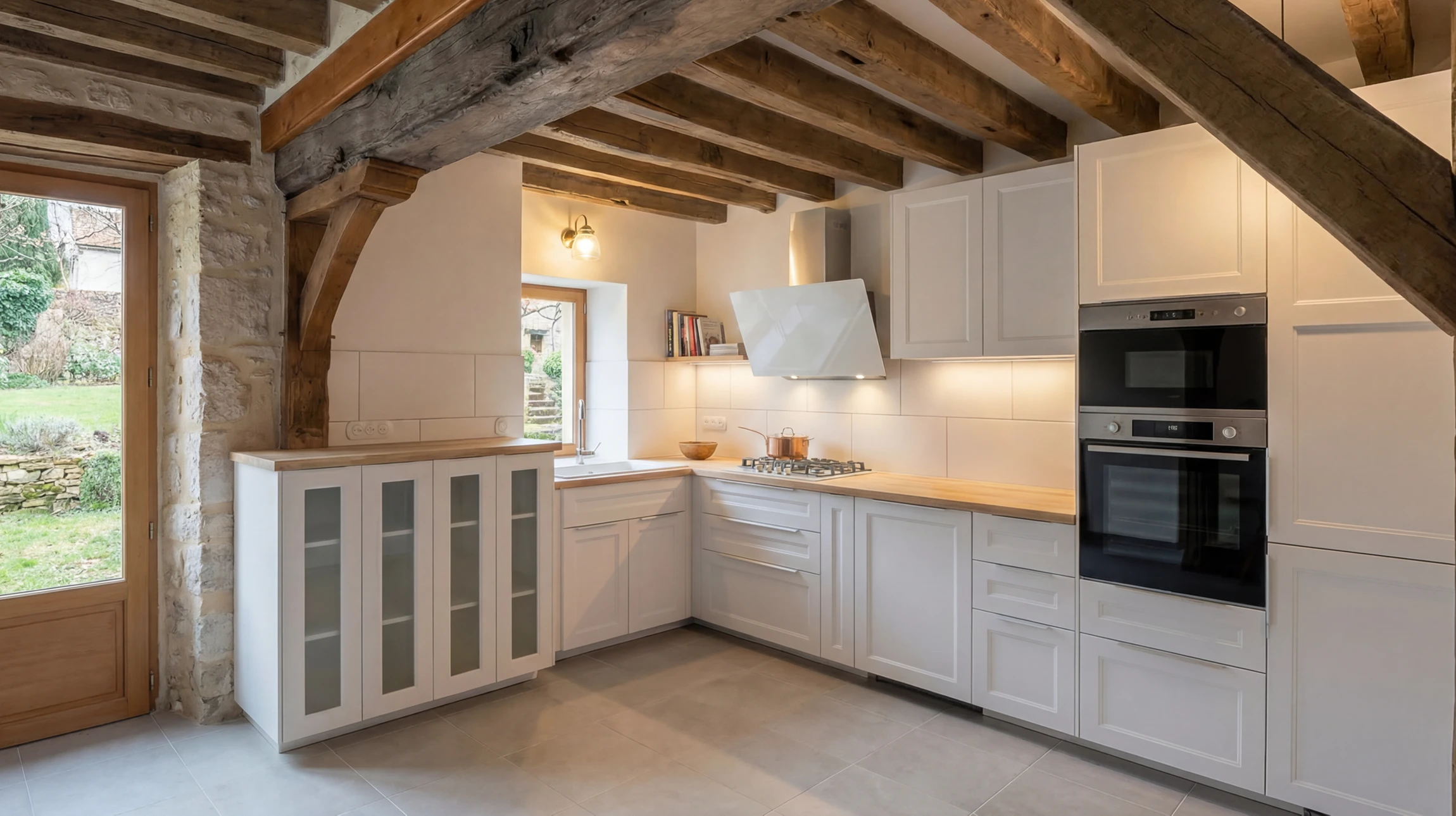 Cuisine moderne &eacute;quip&eacute;e avec &icirc;lot central, &eacute;lectrom&eacute;nager int&eacute;gr&eacute; en acier inoxydable, cr&eacute;dence en carrelage m&eacute;tro blanc