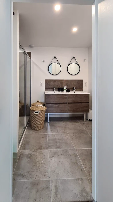 Toilettes suspendues modernes dans petit espace carrelé beige travertin