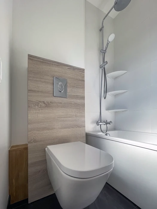 Salle de bain moderne avec douche à l'italienne semi-ouverte, carrelage beige grand format au mur, receveur de douche blanc encastré
