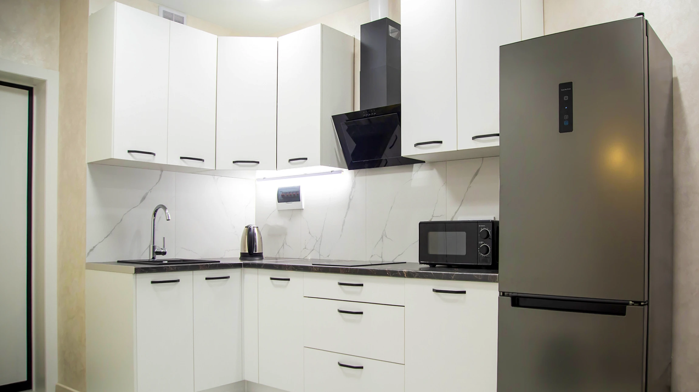 Cuisine moderne ouverte avec îlot central et trois tabourets en bois