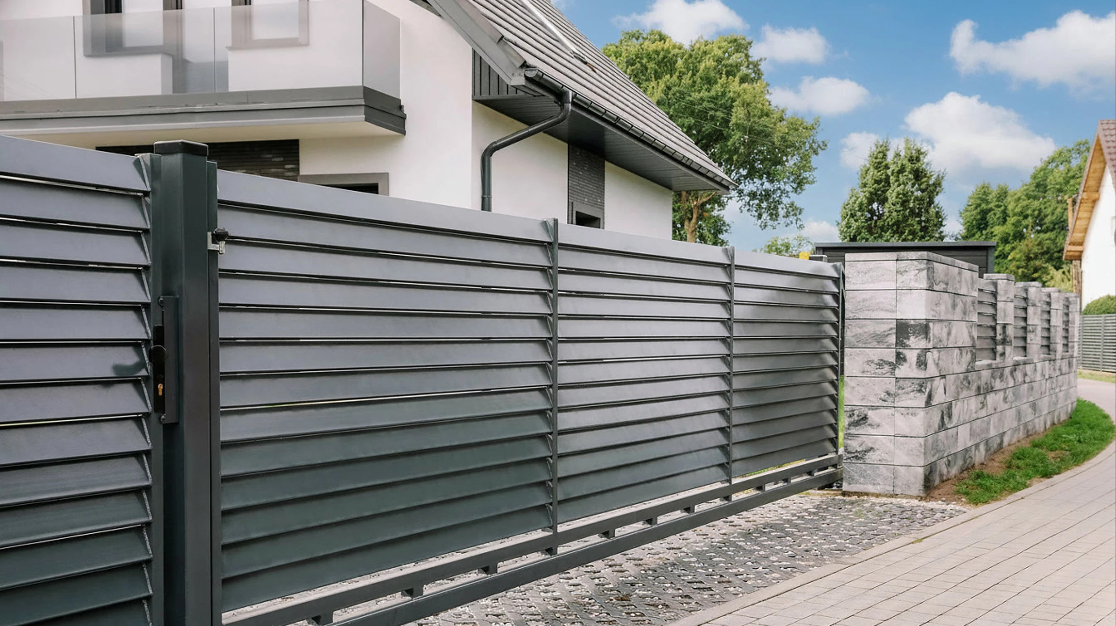 Portail métallique automatisé en cours d'ouverture devant une résidence
